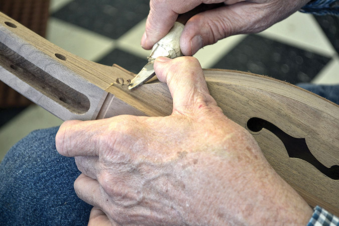 Warren May’s crafting hands at work, “getting the wood to curl just so.”