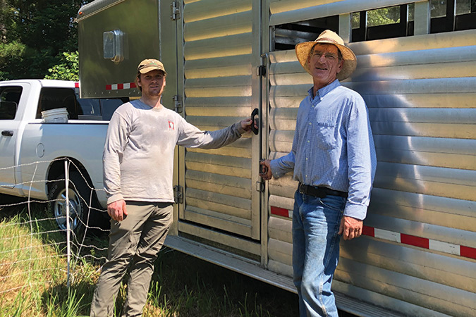 Goat Busters owner Jace Goodling, right, and son Clarke prepare to release their hungry goats from the trailer.