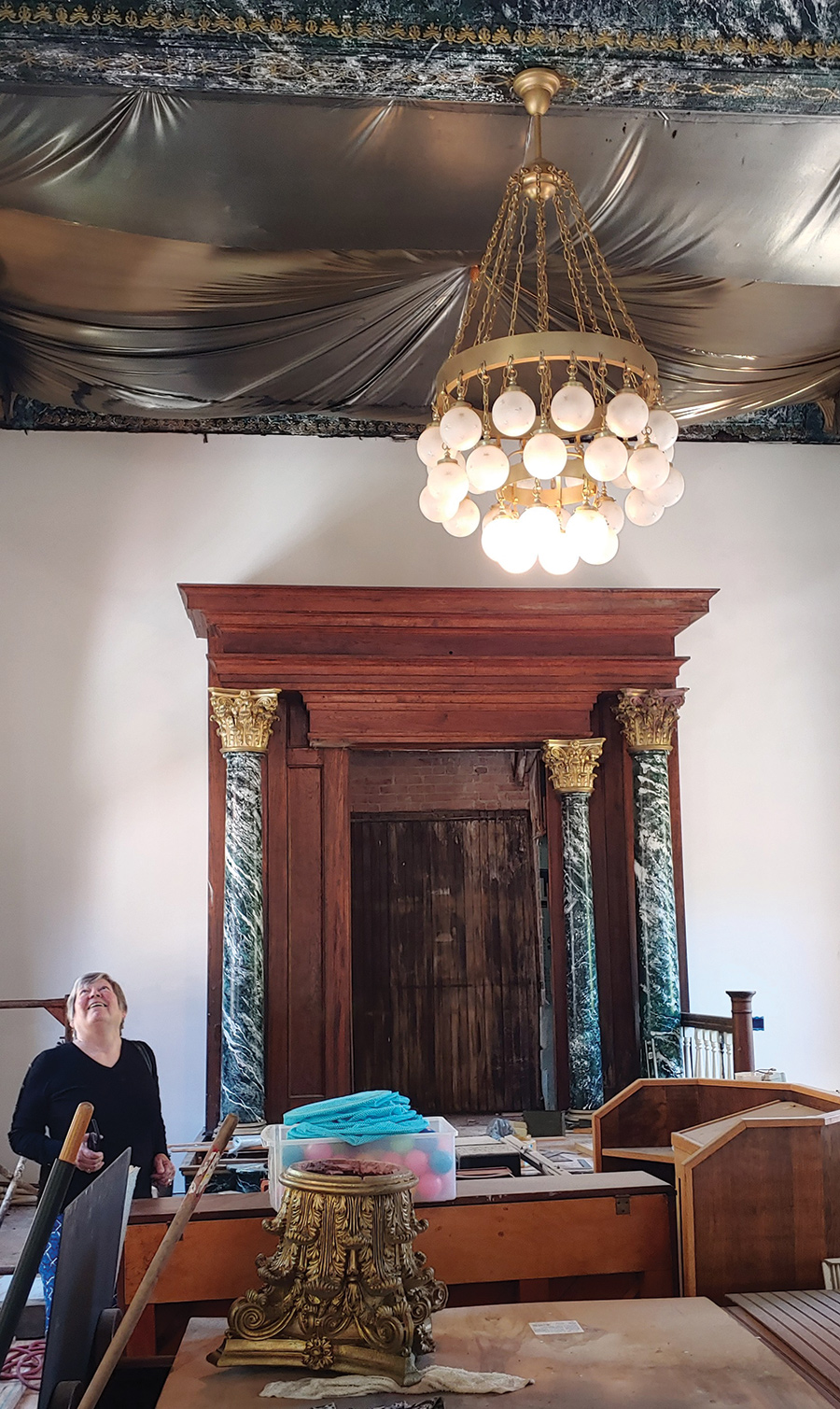 The original globe chandelier illuminates restoration work on the Torah ark.