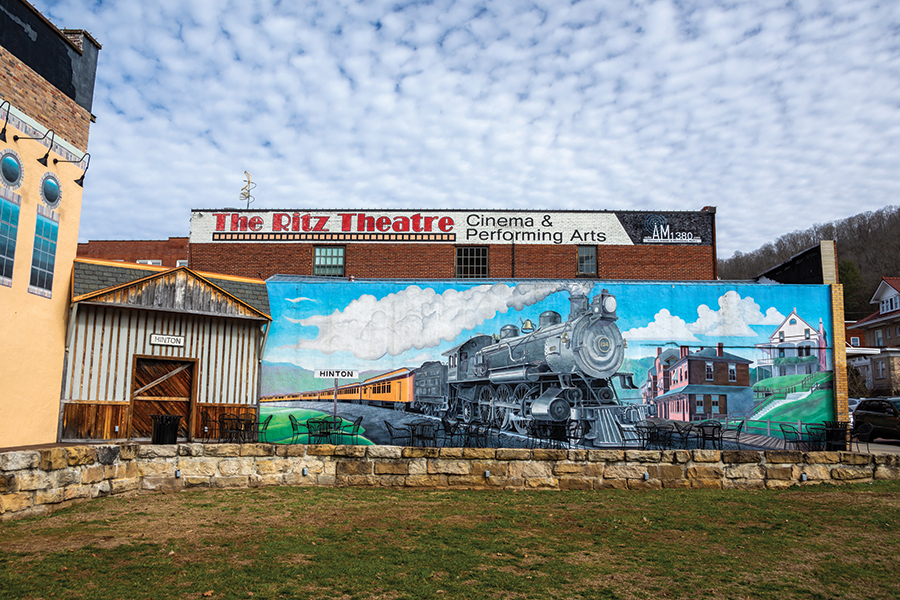 Tom Acosta painted this mural along the side of the historic Ritz Theatre in Hinton, West Virginia, showcasing its history as a railroad town along the New River.