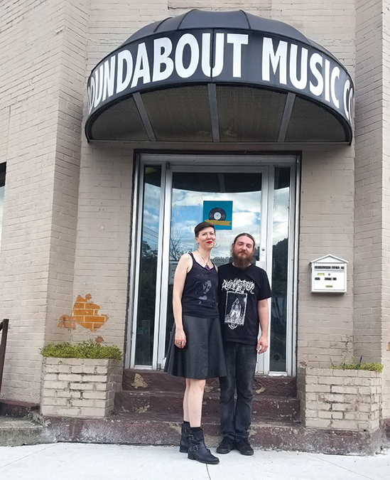 Ben Spangler and his wife, Lacy Hale, stand outside their center-of-Whitesburg Roundabout Music Shop, where old-time, bluegrass and punk/metal music happily coexist.