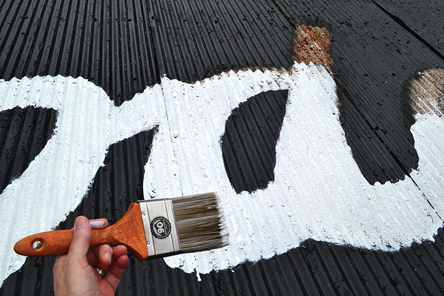 Angela Minor paints a rusty letter “d.”
