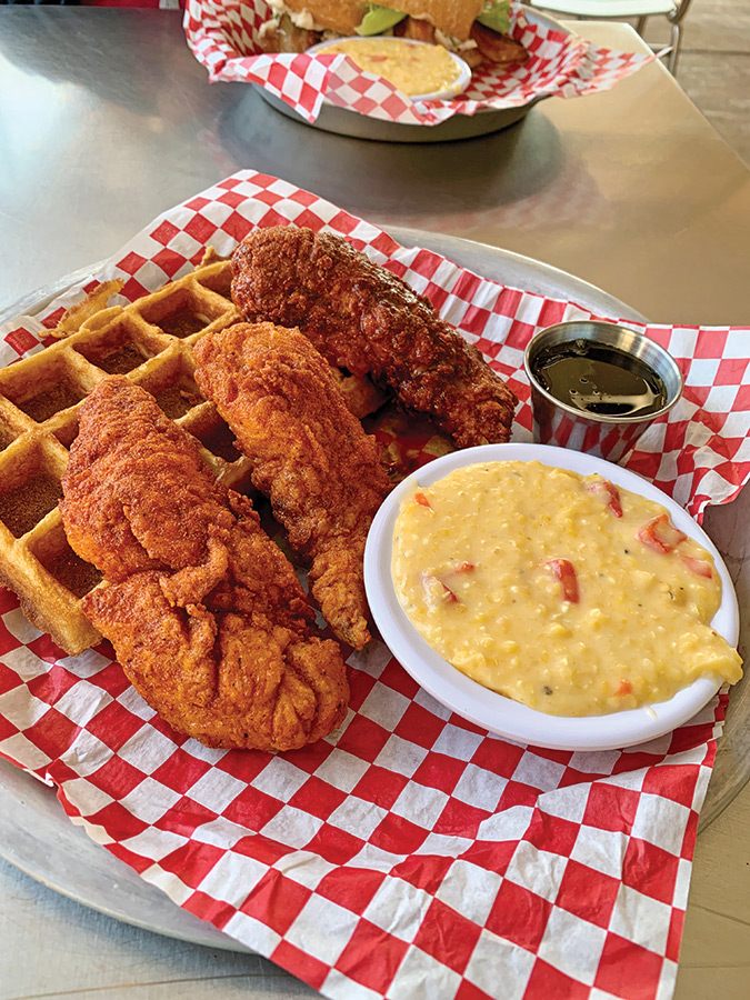 Chicken and waffles are served with pimento cheese grits, at Rocky’s Hot Chicken, Asheville.