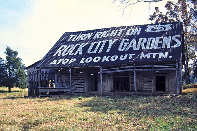 On U.S. 411 near Madisonville, Tennessee, this is a log barn, but since publication of the Rock City Barns book, the owners have covered it with boards and painted it red. Sign is faded, but readable.