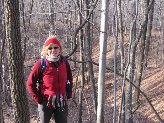 Gail in front of what looks like a classic Appalachian mountain sinkhole along the Chestnut Ridge Loop Trail.