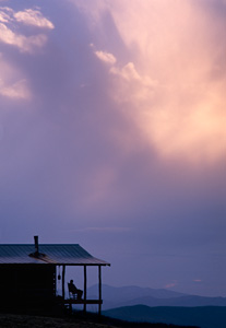 Lingering twilight slowly overtakes a porch “setter” at a rustic cabin northeast of the Smokies.