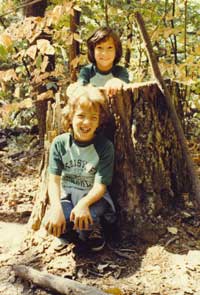 The editor, Cara Ellen Modisett, age 10, in tree stump, with her sister Meg, at Natural Chimneys in Mt. Solon, Va. in 1983.