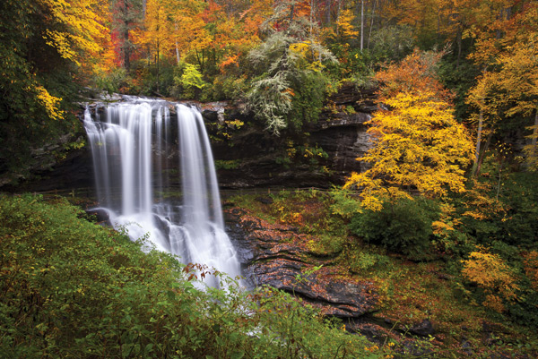 Western North Carolina photographer Dave Allen  won our recent Facebook photo contest with this shot, which he calls Autumn at Dry Falls. In case you want to visit:
Where it is:  Outside of Highlands, N.C.
How to get there: Take U.S. 64 west out of Highlands toward Franklin. 
To reach it:  There is newly remodeled parking and restrooms, and a handicap-accessible viewing platform for those who can’t make it down the stairs and trail to the falls. The steps and groomed trail lead down to the falls and even behind the waterfall.
 Why it’s worth the short walk:  It’s easily one of the most beautiful waterfalls in the Southern Appalachians in Allen’s opinion, and considering the ease of access it should be high on anyone’s list of places to visit.

For more photos from our contest, visit: 
BlueRidgeCountry.com/Waterfalls