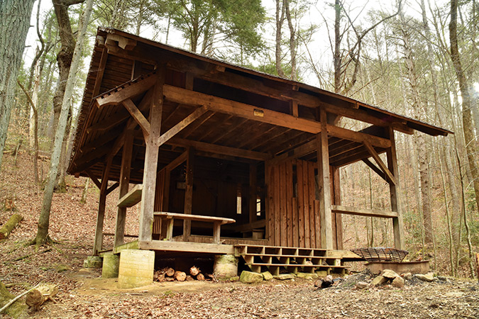 Bryant Ridge Shelter (VA).This unique trilevel timber-frame shelter with an open loft design is dedicated to the memory of Nelson Leavell Garnett Jr. Built from a plan designed by Garnett’s architecture school classmates and converted to timber-frame construction, the shelter was a cooperative project of the ATC, NBATC, USFS, Garnett’s family, and several area firms. Garnett’s parents, in memory of their son who loved hiking on the A.T., helped with the costs. A set of logging horses pulled the timbers to the site from the closest road.