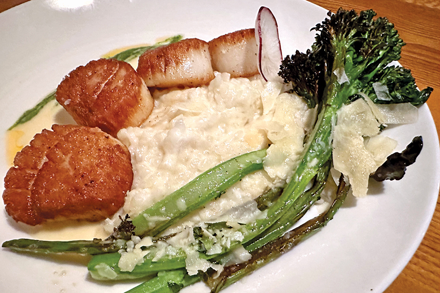 Seared scallops are served in the springtime with ramp pesto and sprigs of broccolini.