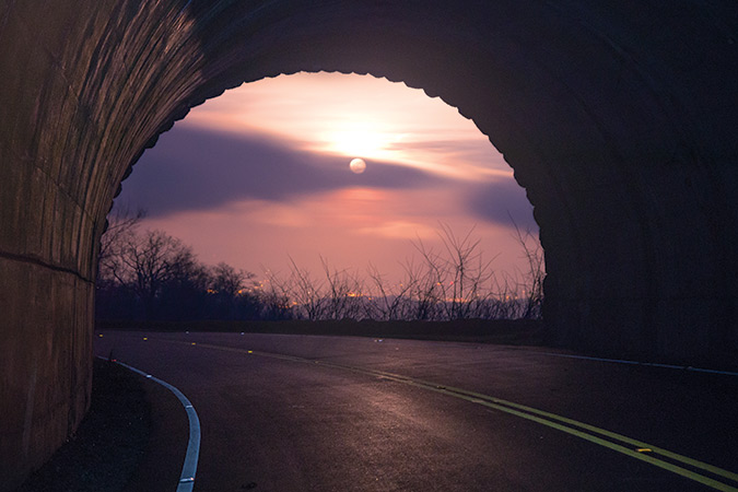 The moon rises over the lights of Arden, North Carolina, as seen from the Buck Springs Tunnel, at North Carolina Milepost 407.3. At certain times of the year, both the moonrise and sunrise can be viewed from within this tunnel.