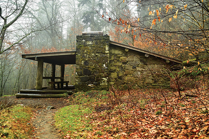 Pecks Corner Shelter (TN). This is a large stone and wooden shelter with a double sleeping platform, skylights, wooden benches, and a fireplace. Located 0.4 miles down the Hughes Ridge Trail, Pecks Corner is one of the only shelters in the park not a short distance from or directly on the A.T.