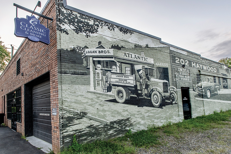 The Logan Brothers Mural painted on the side of the Classic Cleaning and More store at 202 Haywood in West Asheville, North Carolina. The mural, which represents the original businesses at that location, was commissioned by the owners in 2019. It was painted by muralist Scott Allred of Brushcan Custom Murals and Hand Painted signs.
From the artist, Scott Allred: “That mural  has been referred to as the 202 Haywood Mural and the Sepia Tone Mural, but I like to call it “The mural of the building on the building” because that’s literally what it is. It combines two eras. Logan Bros Hauling had a fleet of trucks in the ‘20s and ‘30s, hauling coal and other heavy things. Then in the late ‘40s and early ‘50s, Allied Tire moved in and opened a service station. I painted the mural in June of 2019.”