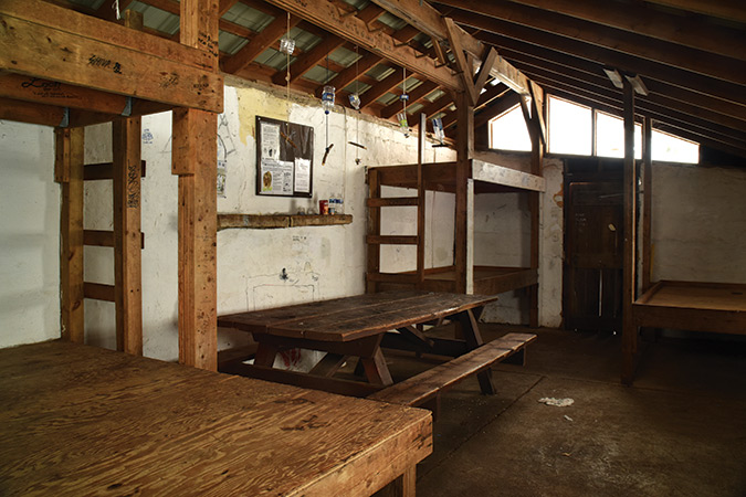 Chestnut Knob Shelter (VA). A former USFS fire warden’s cabin with a fire tower, this fully enclosed stone shelter has plexiglass windows and three sets of wooden bunks. It overlooks the craterlike formation of Burke’s Garden, also known as “God’s Thumbprint.” The valley sits at 3,000 feet and is the highest mountain valley in Virginia. The name Burke’s Garden was given to the valley as a joke in 1748 after Burke planted potato peelings by his campfire and potatoes sprouted the next year. Today, the area is believed to have some of the most fertile farmland in the state.
