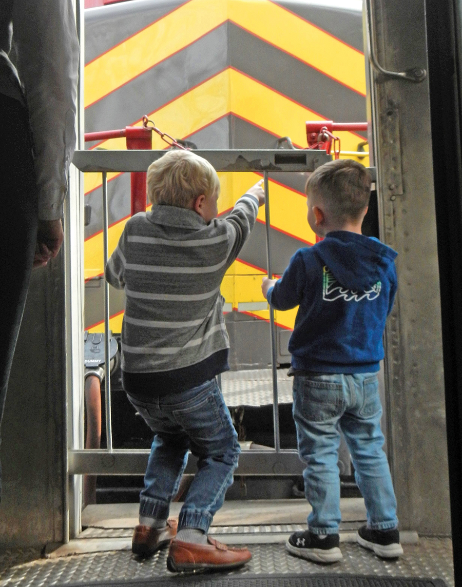 Young passengers watch from the veranda as the train makes its runaround.