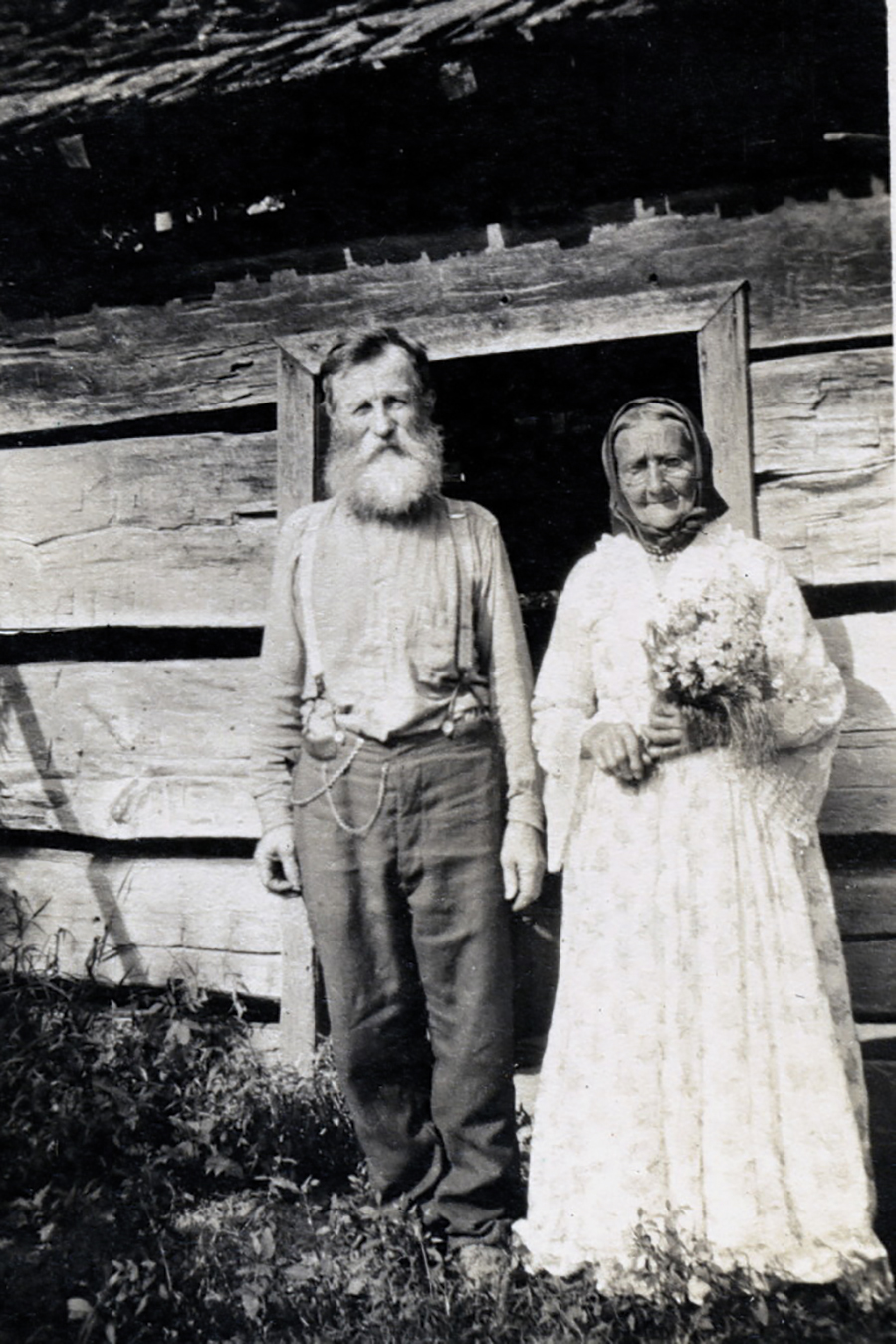 Uncle William and Aunt Sal Creech pose during a 1916 Founder’s Day celebration, standing in front of their first cabin home and re-enacting their wedding of 50 years earlier.