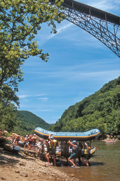 Rafters carry their float out of the New River under the New River Gorge Bridge near Fayetteville.