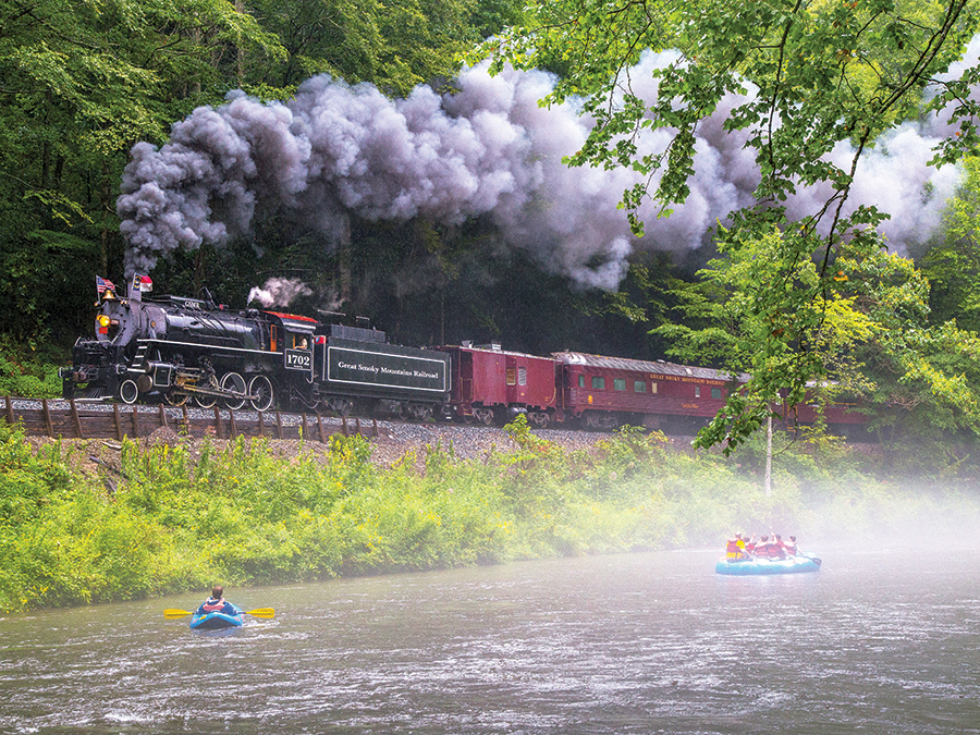 Great Smoky Mountain Railroad’s 2-8-0 Consolidation steam locomotive leads the westbound Nantahala Gorge excursion along the banks of the Nantahala River near Wesser, North Carolina.