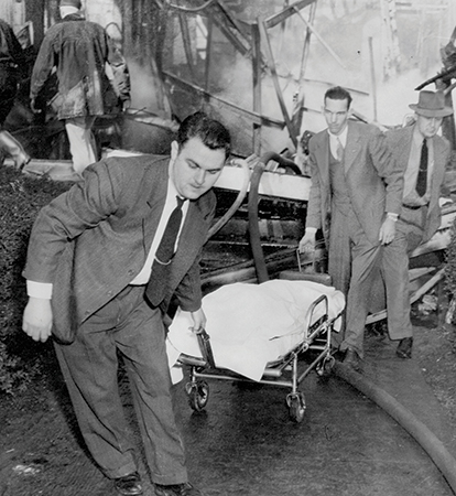 Men in suits carried out the task of wheeling charred remains from Highland Hospital in Asheville.