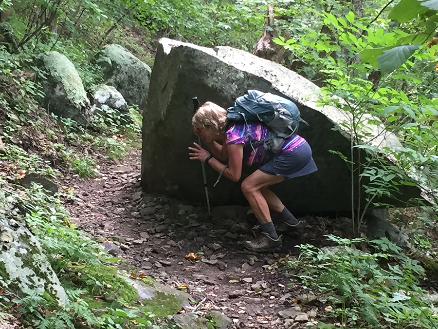 This re-creation of a trail crime has Gail crouching behind a rock so she can jump out and scare an old man should he ever reach the point of the rock in his slog up the mountain.