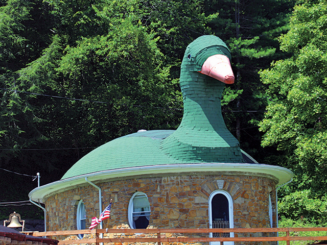 The goose – its head reaching 
up 15 feet – nests upon the house, with the tail extending at the back.