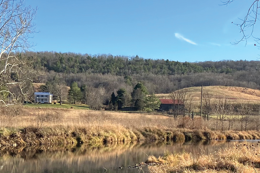 The park office, located in the original farmhouse, and barn overlook River Loop Trail along the Bullpasture River.