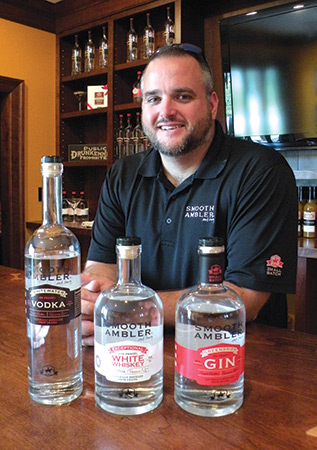 Galyean’s son-in-law John Little stands with a sampling of product at Smooth Ambler Spirits distillery.