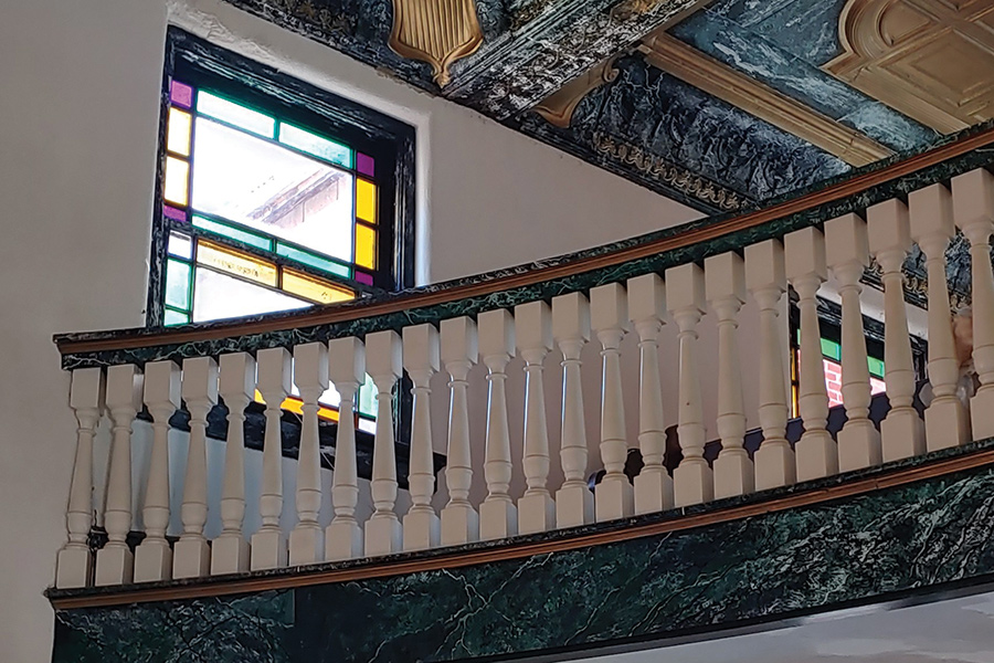 Simple stained-glass windows brighten the traditional women’s balcony.