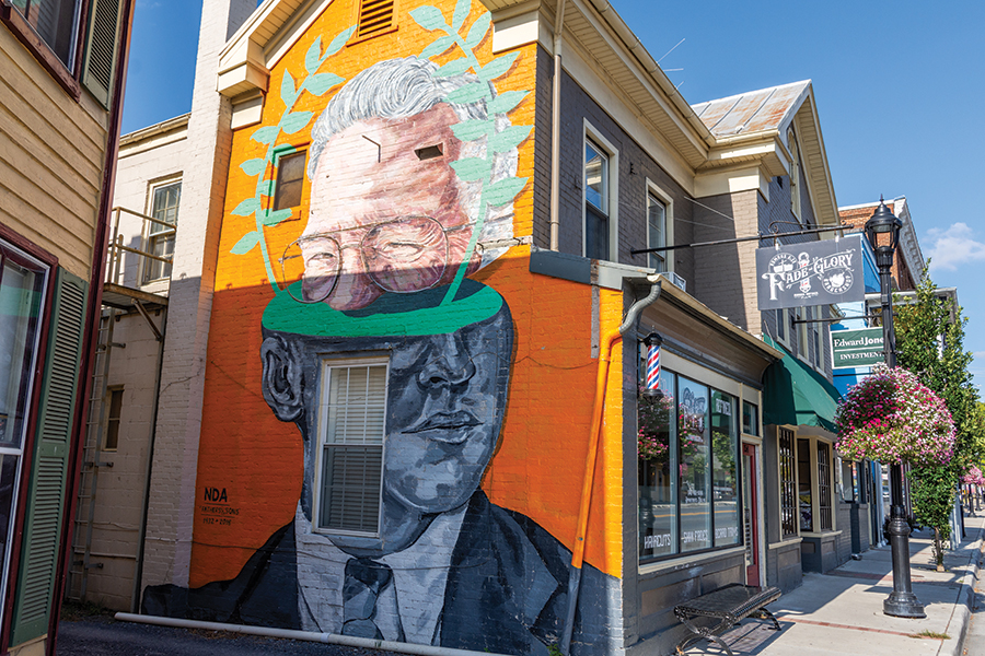 The Fathers and Sons mural was painted by NDA, a public and gallery artist based from Philadelphia, along the main strip of Strasburg, Virginia, in 2016. From the photographer: “The bottom portion of the painting is of a man whose photo he found from town and the top part of the painting is of that mans’ son, who he tracked down through various phone calls. The man on the bottom is father, and the top portion of the painting is actually the son, who had aged.”