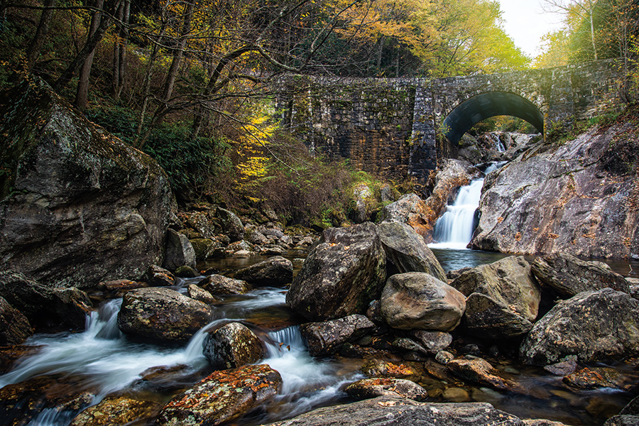 Sunburst Falls, on the West Fork of the Pigeon River, flows under the arched North Carolina Highway 215 bridge near Canton, North Carolina.