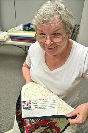 Kathay Pegram, president of the Cleveland, Tennessee, Cherokee Blossom Quilt Guild shows an official Quilts of Valor tag on a current project.