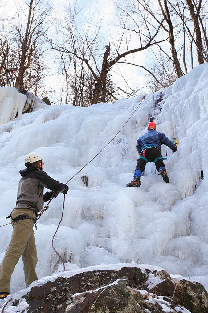 These climbers were on an ice flow on the shady face of lower White Oak Canyon in Shenandoah National Park, Virginia. Flows form when water runs through the layers of rock in the ground and encounters a cliff face where the water exits the rock, where it is frozen by sub-freezing temperatures of the air. To create a large flow requires the ground to stay above freezing, but for the air to remain subfreezing for an extended period.