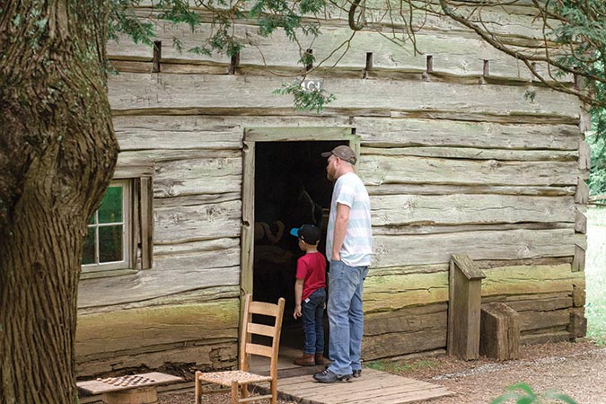 Kayden and Joe explore the historical buildings at Mabry Mill.