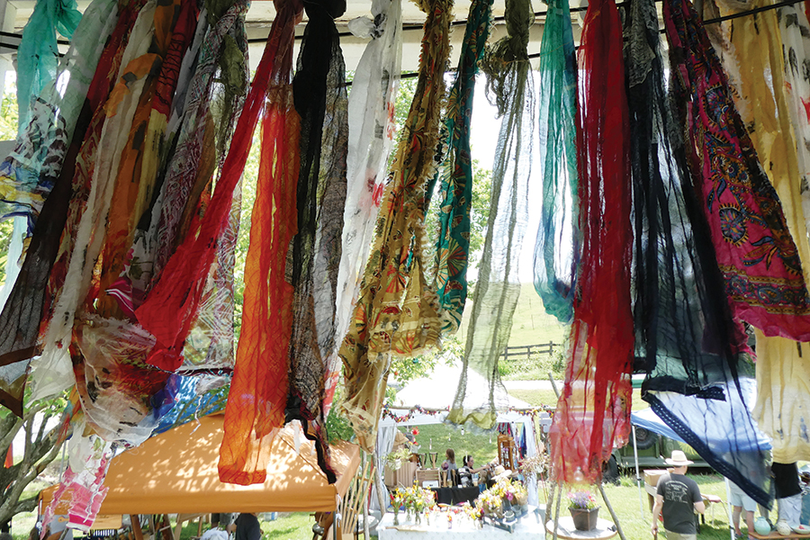 Rag curtains hang over the front porch at Nellie’s Flower Farm and sway in the breeze, emphasizing the peaceful hippie vibe of the place.