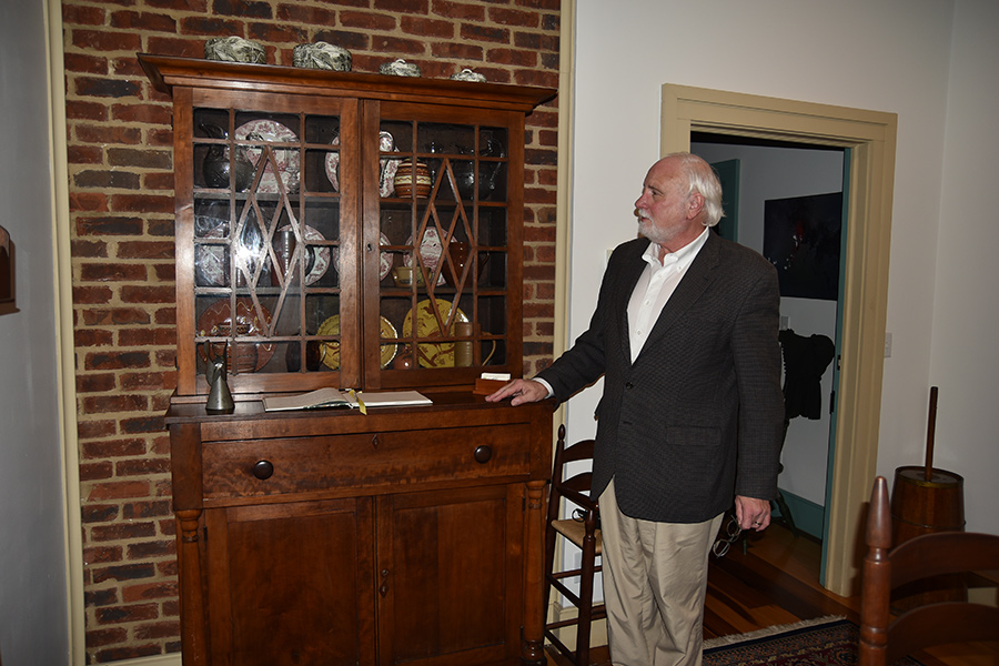 Innkeeper Rick Humphreys shows off an antique china press at A Tailor’s Lodging.
