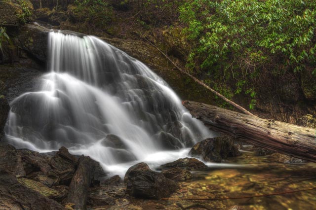 Engine Falls is off of Sams Branch in the Pisgah National Forest.  This branch is very similar to Flat Laurel Creek though a much smaller version.  It is a series of cascades that traverse towards Hwy 215 near the Blue Ridge Parkway.  The photograph taken of Engine Falls is just one of many cascades on this branch.  The name is given from the history behind this location.  The trail towards the cascades is actually an old railroad grade and engines would stop here to get water for their steam engines.  Hence the name Engine Falls.