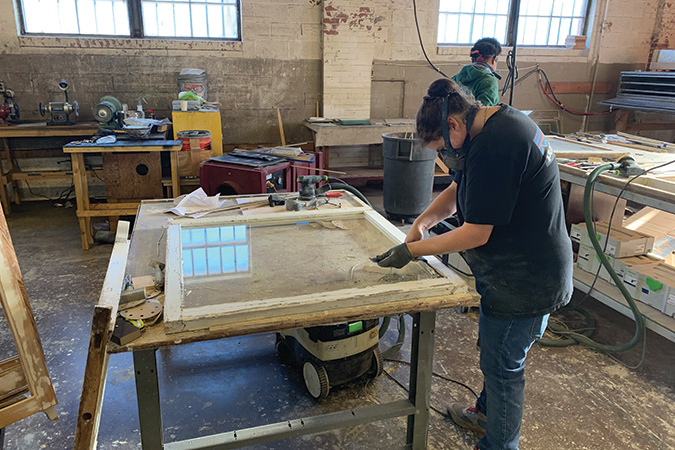 Workers at a preservation workshop in Greensboro, North Carolina restore windows and other exterior elements.