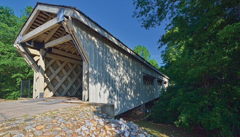 The Hurricane Shoals Bridge near Maysville, Georgia, was originally built in 1882 but was destroyed by vandals in 1972. In 2002 the newly rebuilt, 127-foot bridge was dedicated as part of Jackson County’s Hurricane Shoals County Park.