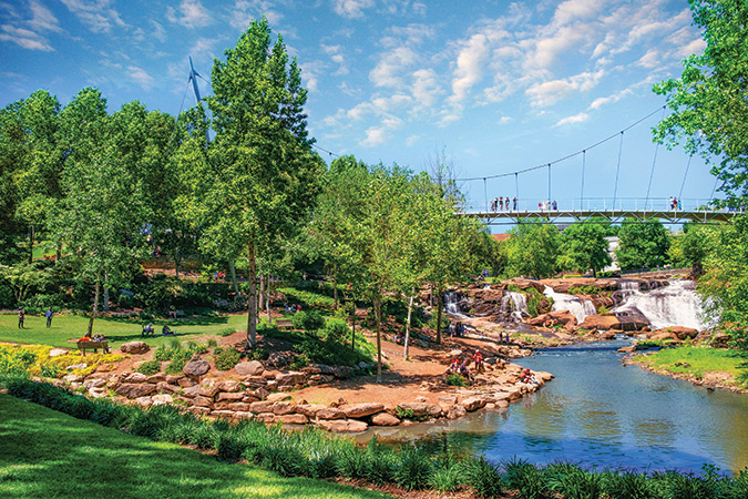 The 345-foot Liberty Bridge sits in the heart of downtown Greenville, spanning the Reedy River as it overlooks an urban waterfall and the rolling gardens of Falls Park on the Reedy River.