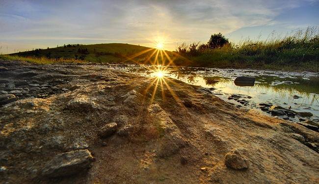 Light on the Trail.

During my North Carolina - Tennessee vacation a few weeks back, I made two separate trips to the Roan Highlands for sunsets. On this particular evening, I was making my way through Engine Gap on my way up to Jane Bald, when I noticed the sun getting ready to sink below the summit of Round Bald. I got down on my belly and noticed a nice sunburst reflection coming off a puddle in the Appalachian Trail. Taking the camera off the tripod and setting it directly on the ground was the only way I was going to be able to capture the scene, so I leveled it the best I could with a few flat stones and snapped off a few shots before heading on up to Jane Bald for my sunset. If you like this image then feel free to share and if you wish, give my photography page a "Like". Thanks for looking!