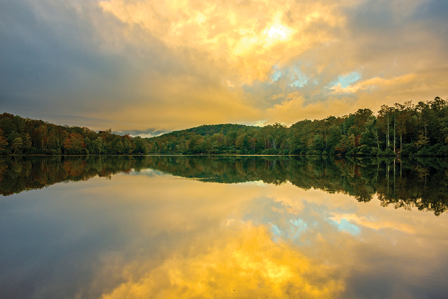 Early morning light reflects along Price Lake as clouds engulf Grandfather Mountain along the Blue Ridge Parkway in western North Carolina.