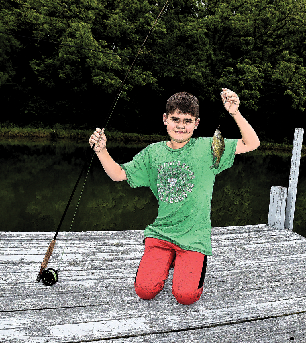 Grandson Eli with a bluegill he caught on a fly rod