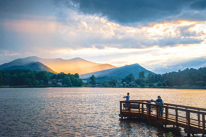 Fishermen wait for the last catch of the day from Meditation Pier as brilliant light rays shine in the distance over Lake Junaluska, located near Waynesville, North Carolina. Photo by Robert Stephens
