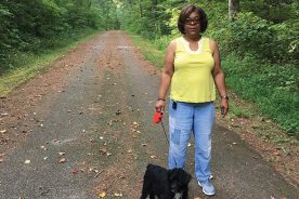 Pam Marshall stands with walking companion Scruffy near the former site of Green Pastures.