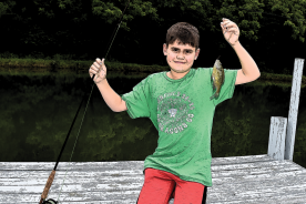 Grandson Eli with a bluegill he caught on a fly rod