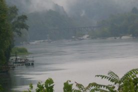 A railroad bridge crosses the New upriver from Gauley Bridge; The Dries are beyond the fog.