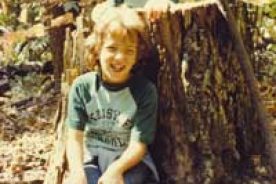 The editor, Cara Ellen Modisett, age 10, in tree stump, with her sister Meg, at Natural Chimneys in Mt. Solon, Va. in 1983.