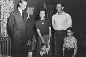 Prince Albert of Belgium stands in the home of dairyman Ralph Peterson and his wife Hazel in rural East Tennessee in 1955. Dale Peterson (far right) and writer Dennis Peterson—content with his thumb—stand by, oblivious to the significance of their unexpected visitor.