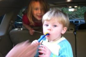 Grayson tries to master the water bladder at the end of the hike as Lily smiles at having done the walk.