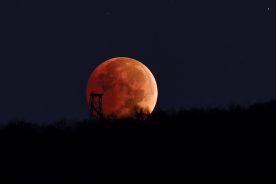 The total eclipsed moon sets behind the Holston Mountain fire tower in Carter County.
